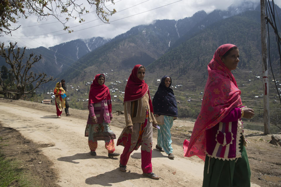 Kashmiri women walk back from a polling station during the second phase of India's general elections, in Baba Nagri, about 44 kilometers (28 miles) northeast of Srinagar, Indian controlled Kashmir, Thursday, April 18, 2019. Kashmiri separatist leaders who challenge India's sovereignty over the disputed region have called for a boycott of the vote. Most polling stations in Srinagar and Budgam areas of Kashmir looked deserted in the morning with more armed police, paramilitary soldiers and election staff present than voters. (AP Photo/ Dar Yasin)