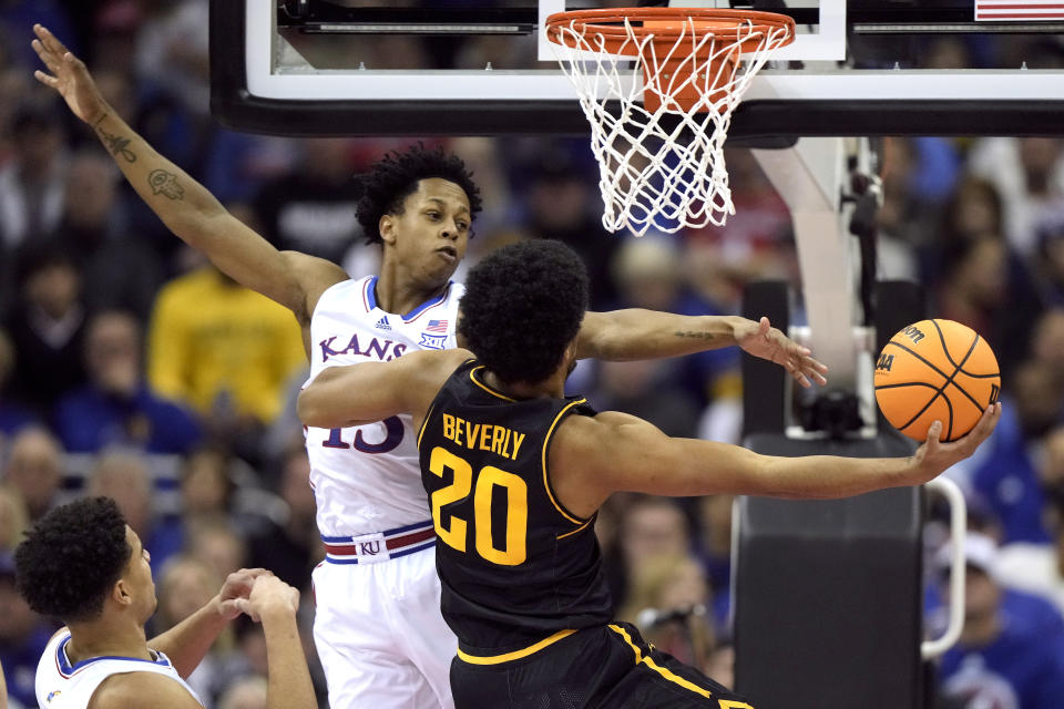 Wichita State guard Harlond Beverly (20) shoots under pressure from Kansas guard Elmarko Jackson during the first half of an NCAA college basketball game Saturday, Dec. 30, 2023, in Kansas City, Mo. (AP Photo/Charlie Riedel)