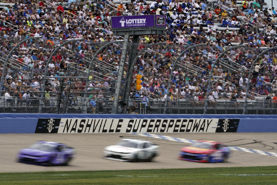 Cars come down the main straightaway at Nashville Superspeedway during a NASCAR Xfinity Series auto race Saturday, June 19, 2021, in Lebanon, Tenn. (AP Photo/Mark Humphrey)