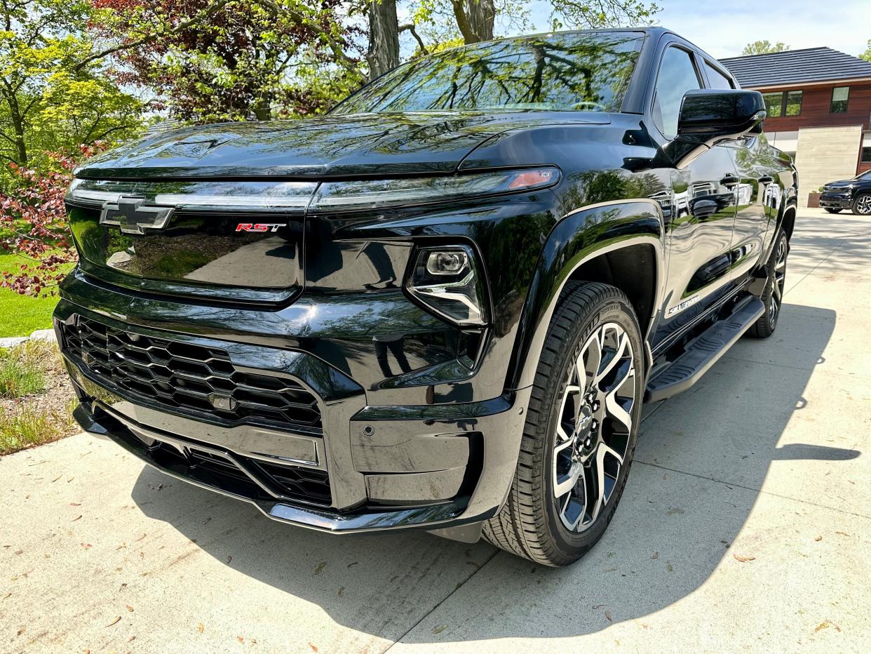 A black Chevrolet Silverado EV RST First Edition parked in a driveway.