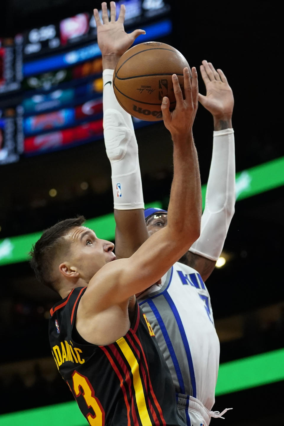 Atlanta Hawks guard Bogdan Bogdanovic (13) goes up for a shot as Sacramento Kings center Richaun Holmes (22) defends in the first half of an NBA basketball game Wednesday, Jan. 26, 2022, in Atlanta. (AP Photo/John Bazemore)