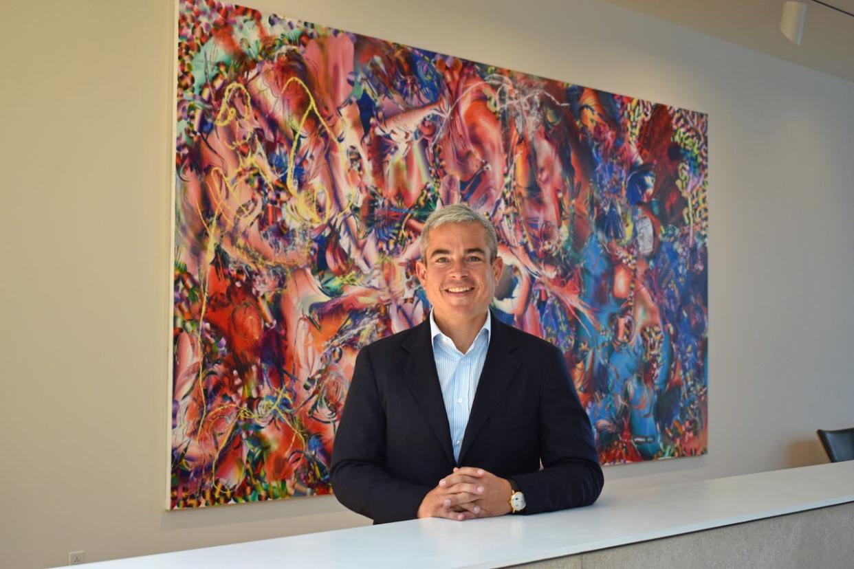 Pete Scantland, founder and CEO of Orange Barrel Media, in front of the painting “Bellweather” by Laura Quin