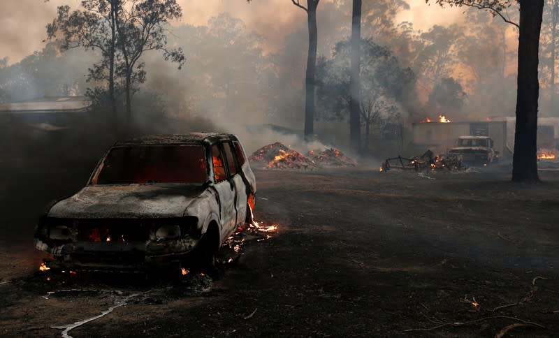 A vehicle burns in the yard of a house on Bullocky Way, Possum Brush, south of Taree in the Mid North Coast region of NSW