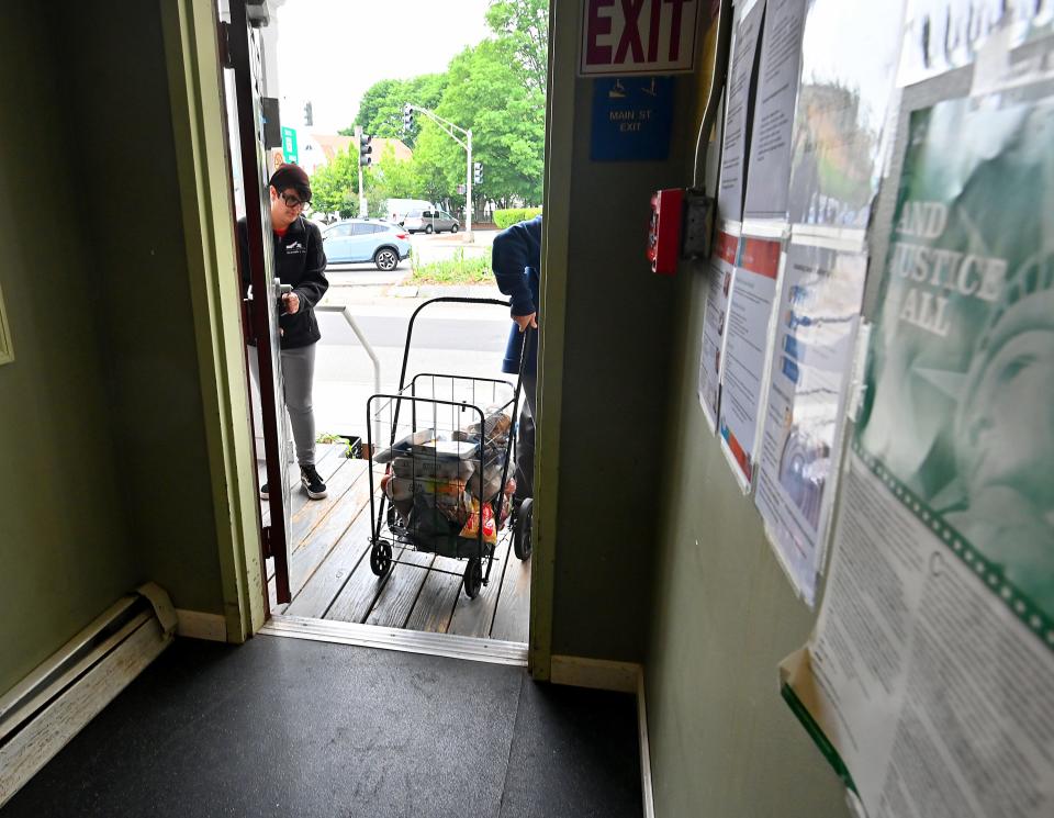 Jeremiah's Inn food pantry Intake Coordinator Serina Connor holds the door open for a client.