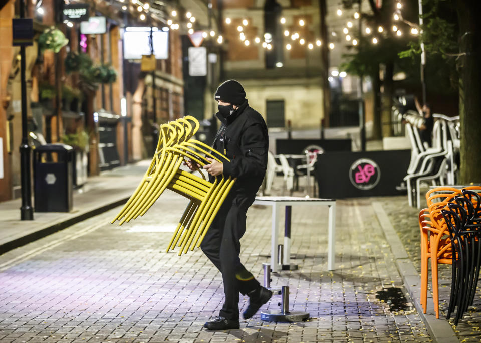 Bar staff clearing away tables for the evening in Manchester. The Government is expected to announce new measures later today that could see pubs and bars forced to close to combat the spread of the virus in northern England and other areas suffering a surge in Covid-19 cases. (Photo by Danny Lawson/PA Images via Getty Images)