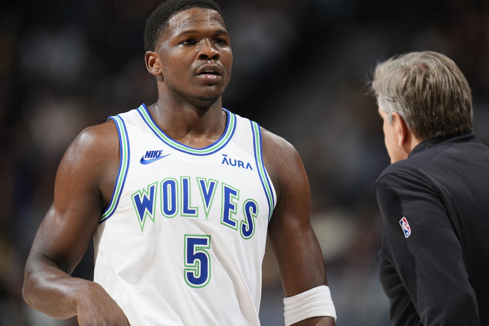 Minnesota Timberwolves guard Anthony Edwards, left, confers with head coach Chris Finch in the first half of an NBA basketball game against the Denver Nuggets Friday, March 29, 2024, in Denver. (AP Photo/David Zalubowski)