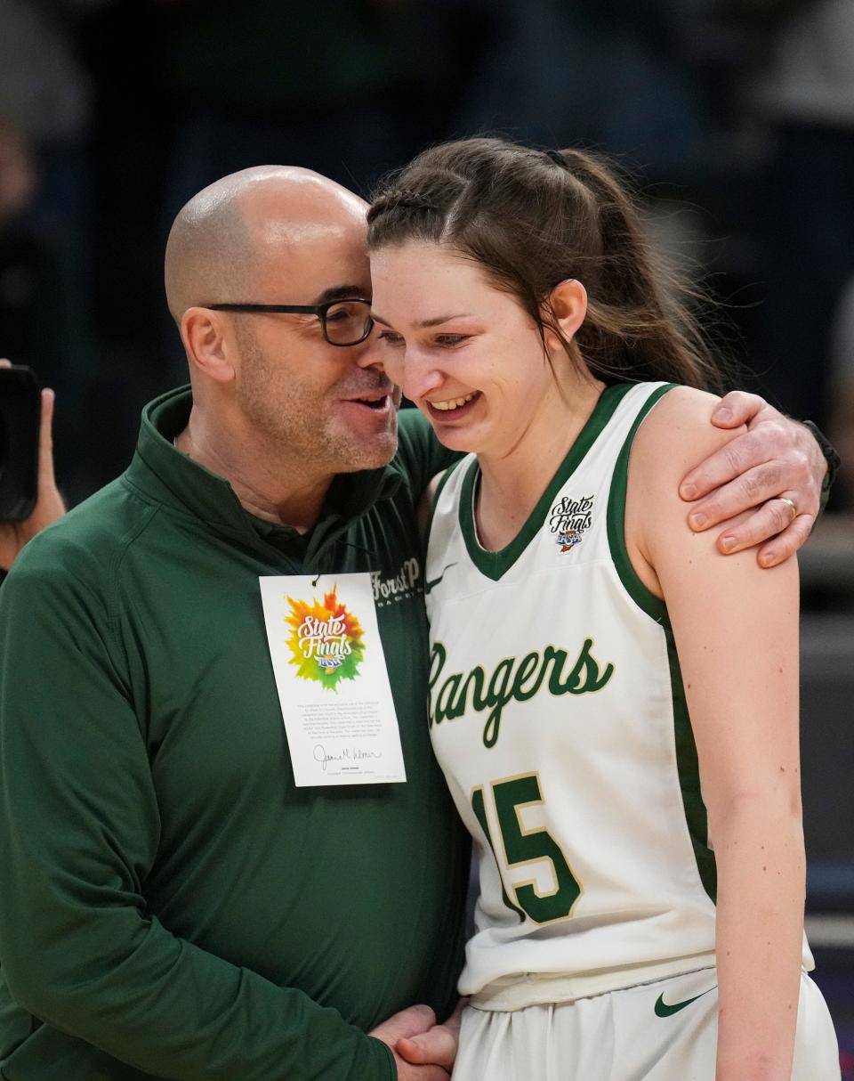 Forest Park Ranger head coach Tony Hasenour congratulates Amber Tretter (15) as she wins the IHSAA Mental Attitude Award Saturday, Feb. 25, 2023, after the Class 2A championship game at Gainbridge Fieldhouse in Indianapolis. Forest Park defeated Lapel for the title, 38-37.