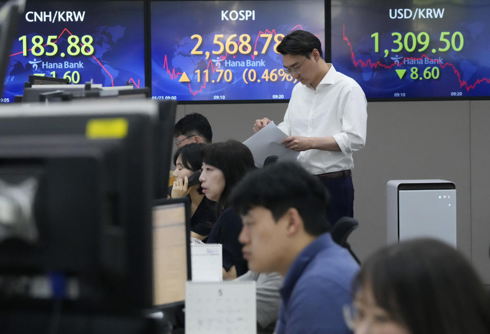 A currency trader works near the screens showing the Korea Composite Stock Price Index (KOSPI), top center, and the foreign exchange rate between U.S. dollar and South Korean won, top right, at the foreign exchange dealing room of the KEB Hana Bank headquarters in Seoul, South Korea, Tuesday, May 23, 2023. Asian stock markets were mixed Tuesday after more talks in Washington on government debt ended with no deal to avoid a potentially jarring default.(AP Photo/Ahn Young-joon)