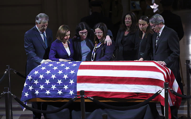 Rep. Nancy Pelosi (D-Calif.) stands with her husband, Paul, left, and the family of Sen. Dianne Feinstein (D-Calif.). Before them is a casket covered by an American flag.
