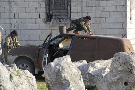 Ansar Al-Sham Brigade fighters camouflage a vehicle with mud near Jisr al-Shoghour, Idlib province March 25, 2015. REUTERS/Mohamad Bayoush