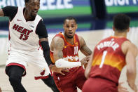 Denver Nuggets guard Monte Morris, center, looks to pass the ball to forward Michael Porter Jr., right, as Miami Heat center Bam Adebayo defends in the first half of an NBA basketball game Wednesday, April 14, 2021, in Denver. (AP Photo/David Zalubowski)