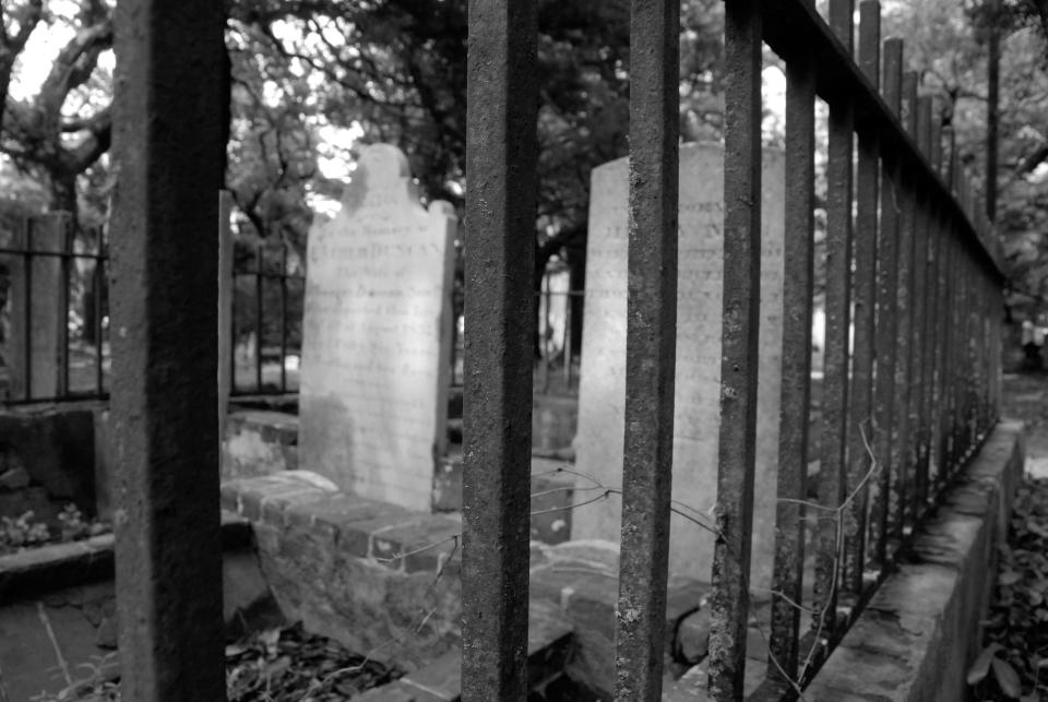 A rusted iron fence marks off a family gravesite.