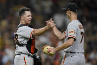 San Francisco Giants catcher Buster Posey, left, celebrates with relief pitcher Tyler Rogers after the Giants defeated the San Diego Padres 6-5 in a baseball game Tuesday, Sept. 21, 2021, in San Diego. (AP Photo/Gregory Bull)