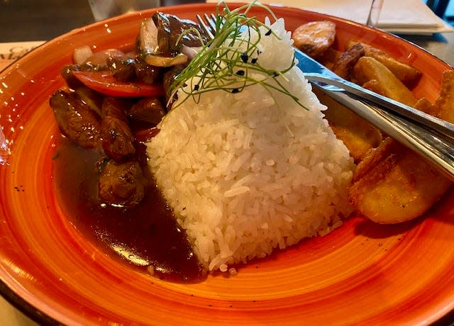 Lomo saltado, served with frice and fries, is one of the Peruvian classics on the menu.