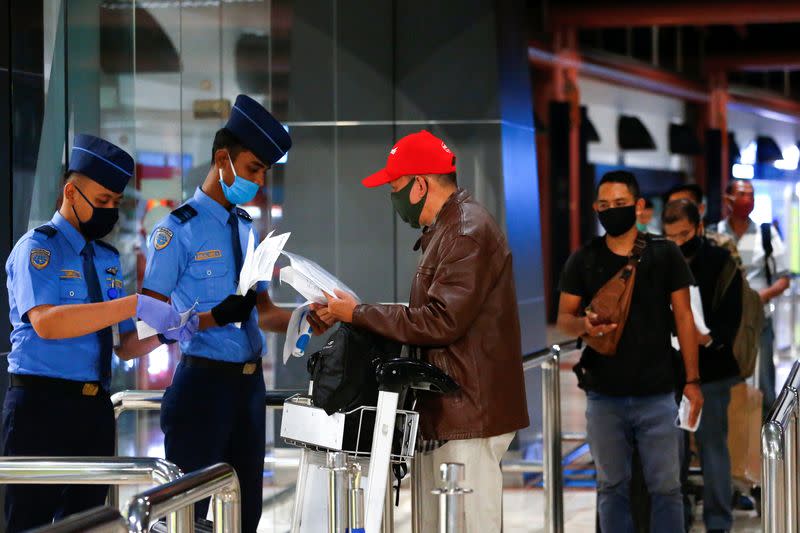 Passengers stand in line to have documents checked before boarding flights at a Soekarno Hatta Airport amid the coronavirus disease (COVID-19) outbreak in Jakarta