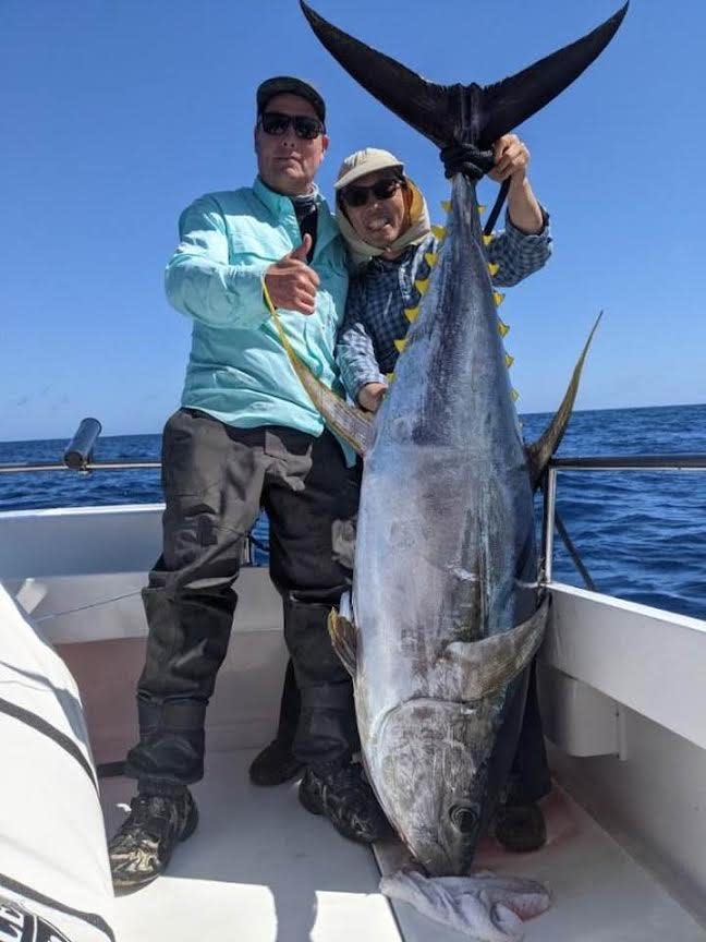 Dylan Taube, left, and Edmund Jin show off the gigantic yellowfin tuna, estimated to weigh 240 pounds, that they landed while fishing in the offshore waters of Fort Bragg.