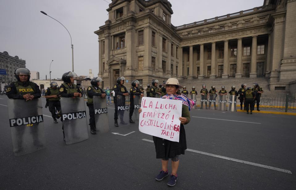 A supporter of outsed President Pedro Castillo holds a poster with a message that reads in Spanish: "The battle has begun, freedom for Castillo", in front of the Justice Palace, in Lima, Peru, Thursday, Dec. 8, 2022. Peru's Congress voted to remove Castillo from office Wednesday and replace him with the vice president, shortly after Castillo tried to dissolve the legislature ahead of a scheduled vote to remove him. (AP Photo/Fernando Vergara)