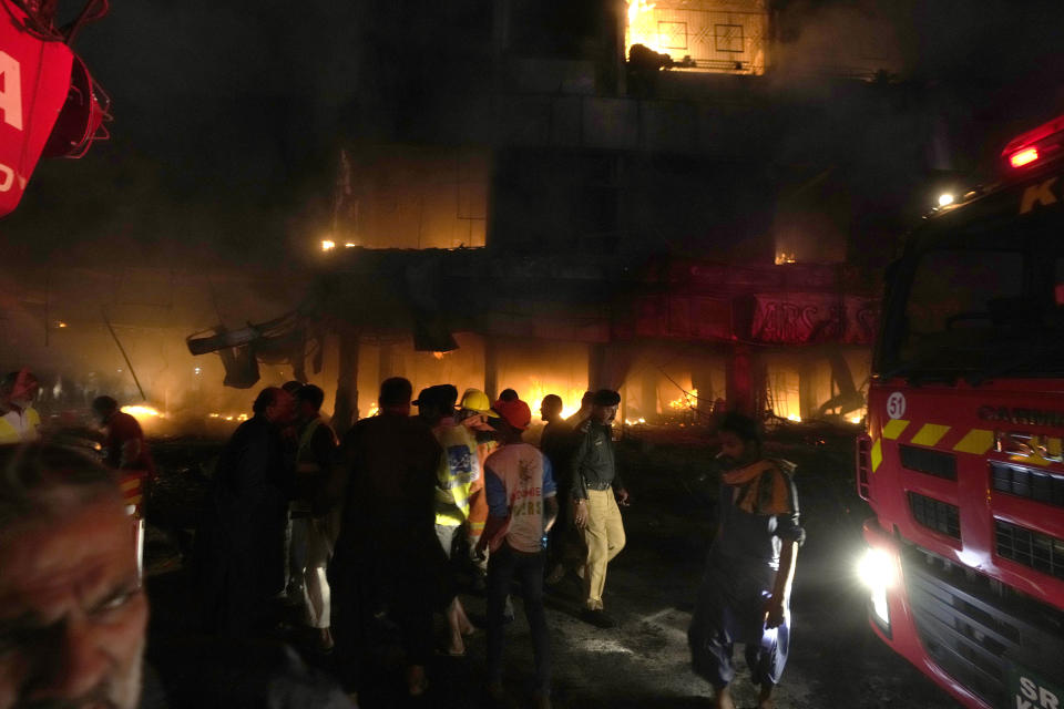 Firefighters struggle to contain a fire at a multi-story commercial building in Karachi, Pakistan, Wednesday, Dec. 6, 2023. The massive fire broke out Wednesday in Pakistan's largest southern port city of Karachi, killing a number of people and damaging several shops, police and rescue officials said. (AP Photo/Fareed Khan)
