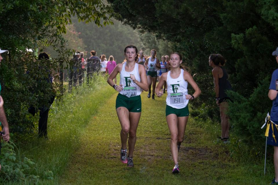 Fleming Island teammates Katie Thompson (left) and Allie Knotts run side by side in the girls varsity cross country race at the Bobcat Classic in Gainesville.