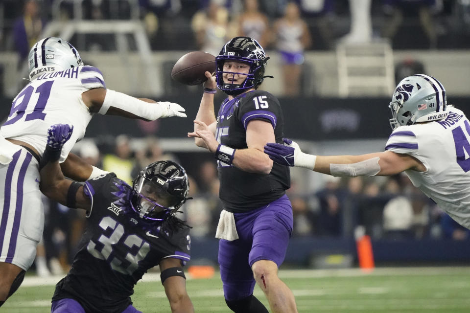 TCU quarterback Max Duggan (15) throws under pressure from Kansas State defensive end Felix Anudike-Uzomah (91) and linebacker Austin Moore (41) in the first half of the Big 12 Conference championship NCAA college football game, Saturday, Dec. 3, 2022, in Arlington, Texas. TCU running back Kendre Miller (33) is at bottom. (AP Photo/LM Otero)