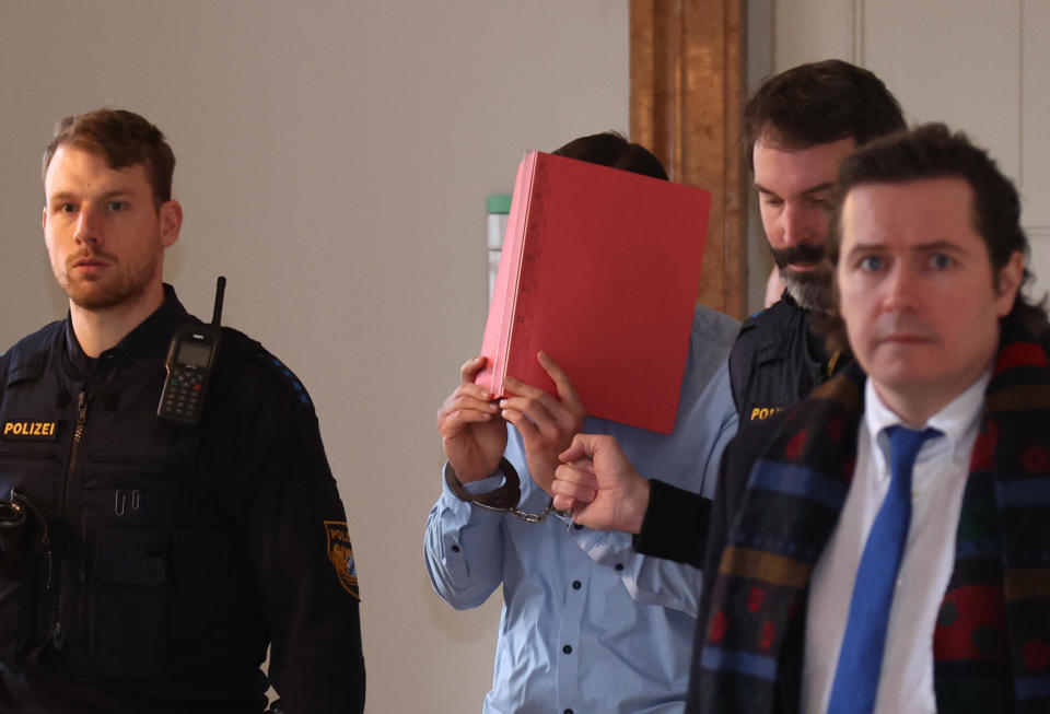 A 31-year-old American man accused of murder is led into the courtroom at the Kempton District Court, Feb. 19, 2024, in Kempten,   Bavaria, southern Germany. / Credit: Karl-Josef Hildenbrand/dpa/Getty