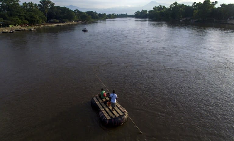 Migrants and residents use a makeshift raft to cross the Suchiate River, which formsl the natural border between Mexico and Guatemala