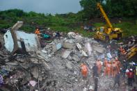 Rescue workers search for people in the rubble of a collapsed five-storey apartment building in Mahad. (Photo by PUNIT PARANJPE/AFP via Getty Images)