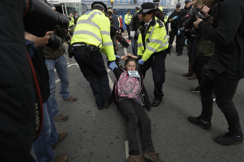 An Extinction Rebellion climate change protester is removed by police from blocking a road outside City Airport in London, Thursday, Oct. 10, 2019. Some hundreds of climate change activists are in London during a fourth day of world protests by the Extinction Rebellion movement to demand more urgent actions to counter global warming. (AP Photo/Matt Dunham)