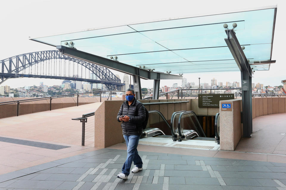 A person walks along the Opera House forecourt on June 24, 2021 in Sydney, Australia. A steady increase in Covid-19 cases in Sydney prompted the government to impose greater restrictions including a mandatory mask mandate indoors and limits on gatherings and movement. Several Sydney suburbs have been declared federal Covid-19 hotspots.