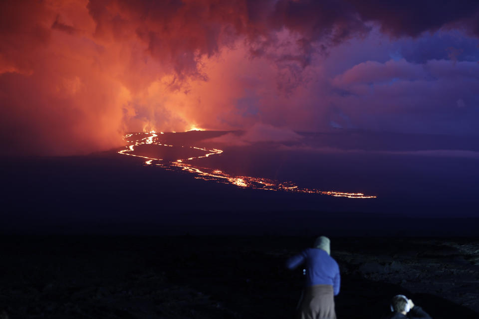 <p>Spectators watch the lava flow down the mountain from the Mauna Loa eruption, Tuesday, Nov. 29, 2022, near Hilo, Hawaii. (AP Photo/Marco Garcia)</p> 