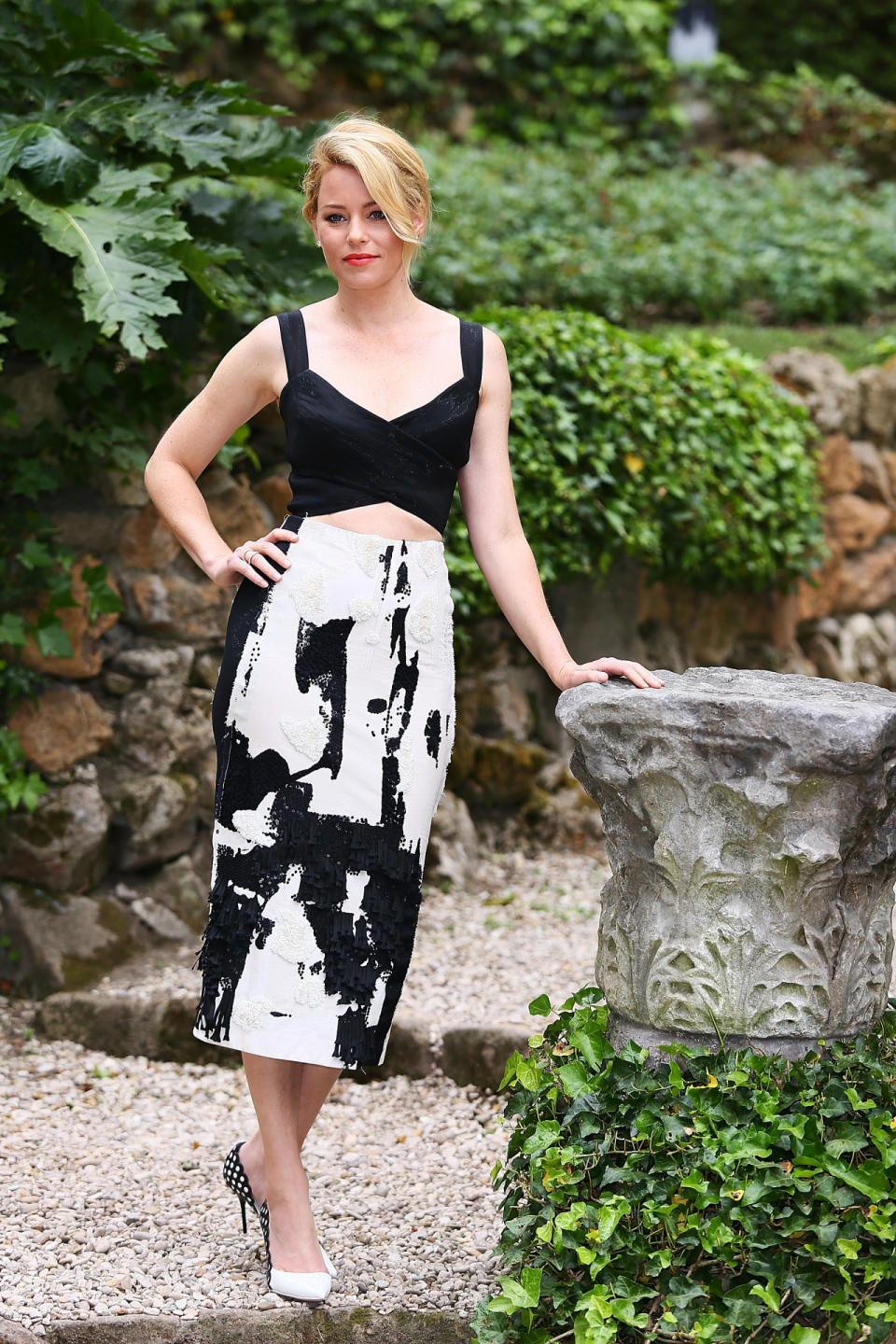 Believe it or not, Elizabeth Banks, posing here against a pile of rocks and well-manicured foliage, is at a press appearance for “Pitch Perfect 2.” In a black and white Donna Karan textured pencil skirt with criss-cross crop top, she looked statuesque. As they say, when in Rome (literally).