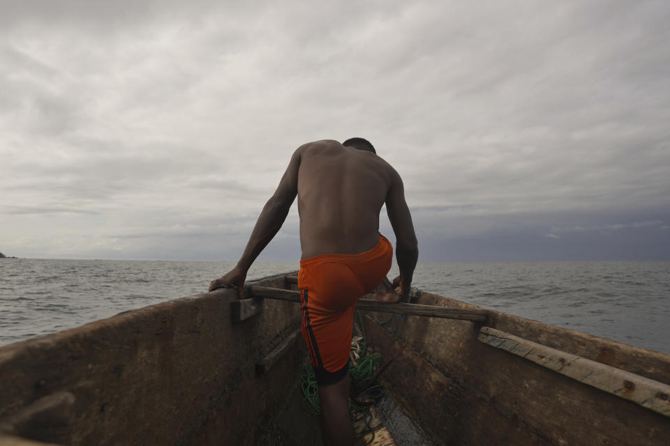 Fisherman Ayafor works in his wooden engine boat in the Atlantic, near Limbe, Cameroon, on April 12, 2022. In recent years, Cameroon has emerged as one of several go-to countries for the widely criticized “flags of convenience” system, under which foreign companies can register their ships even though there is no link between the vessel and the nation whose flag it flies. But experts say weak oversight and enforcement of fishing fleets undermines global attempts to sustainably manage fisheries and threatens the livelihoods of millions of people in regions like West Africa. (AP Photo/Grace Ekpu)