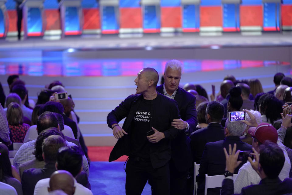 A protester is removed Sept. 12, 2019, after interrupting a Democratic presidential primary debate hosted by ABC at Texas Southern University in Houston. | David J. Phillip—AP