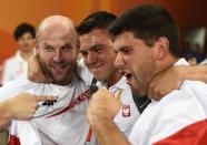 First placed Piotr Malachowski (L) of Poland and his third placed compatriot Robert Urbanek celebrate with their coach Maciej Wlodarczyk (C) after the men's discus throw final at the 15th IAAF World Championships at the National Stadium in Beijing, China, August 29, 2015. REUTERS/Dylan Martinez