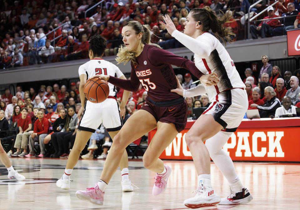 Virginia Tech's Elizabeth Kitley (33) works against North Carolina State's River Baldwin, right, during the first half of an NCAA college basketball game in Raleigh, N.C., Thursday, Feb. 8, 2024. (AP Photo/Ben McKeown)