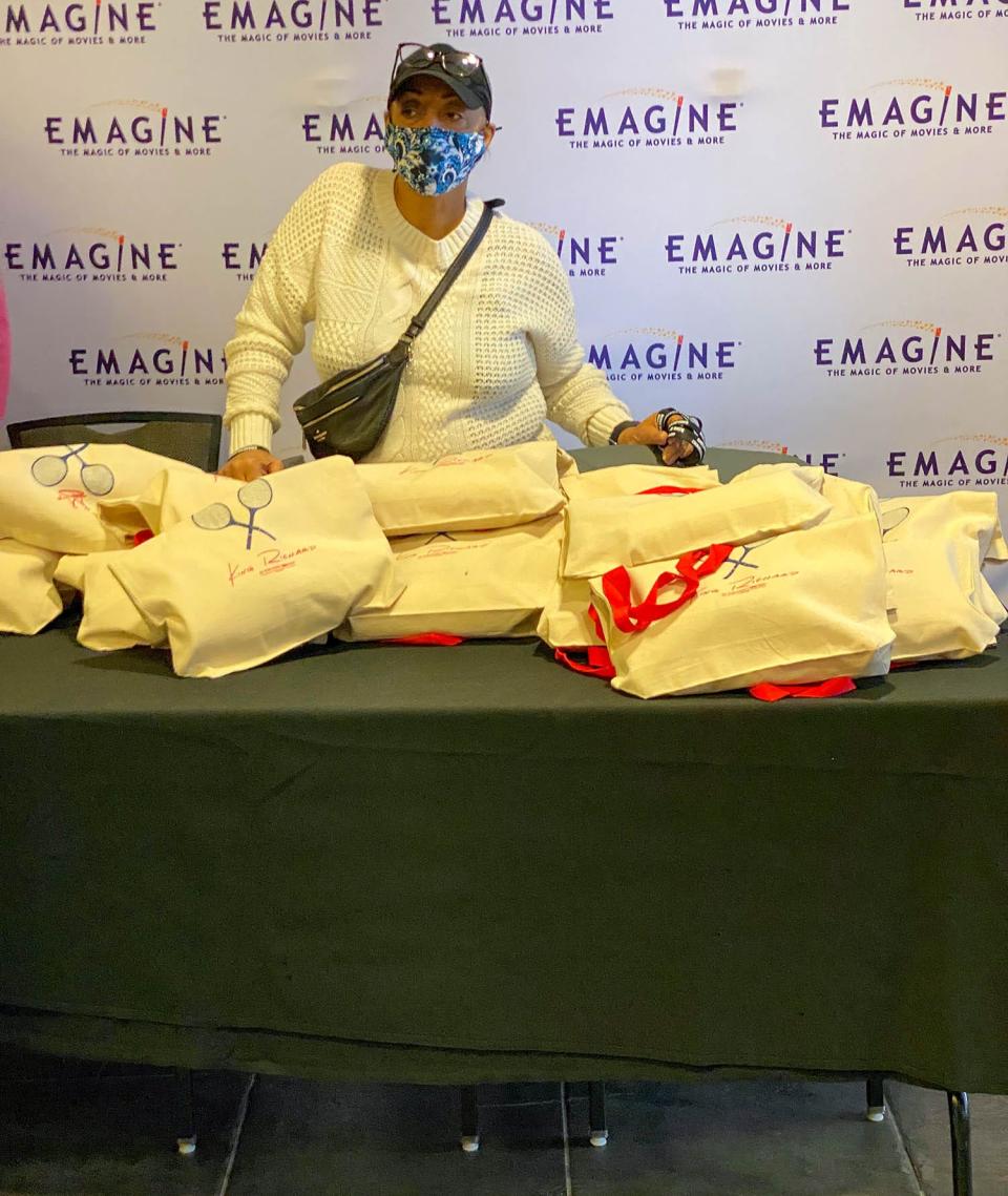 Lavita Cox, a volunteer with “Tuff Cookiez,” stands behind the registration table while waiting for other children to register for the movie "King Richard" so she can hand them a gift bag to take with them into the movie at the Emagine Royal Oak theater, on Nov 20, 2021.