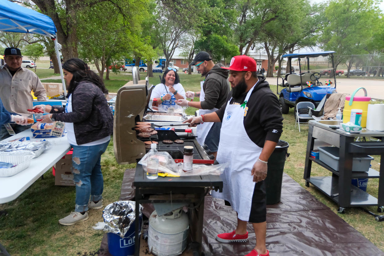 Hot dogs and hamburgers are grilled Saturday at the El Barrio Lions Club annual Cinco de Mayo Celebration at Alamo Park in Amarillo.