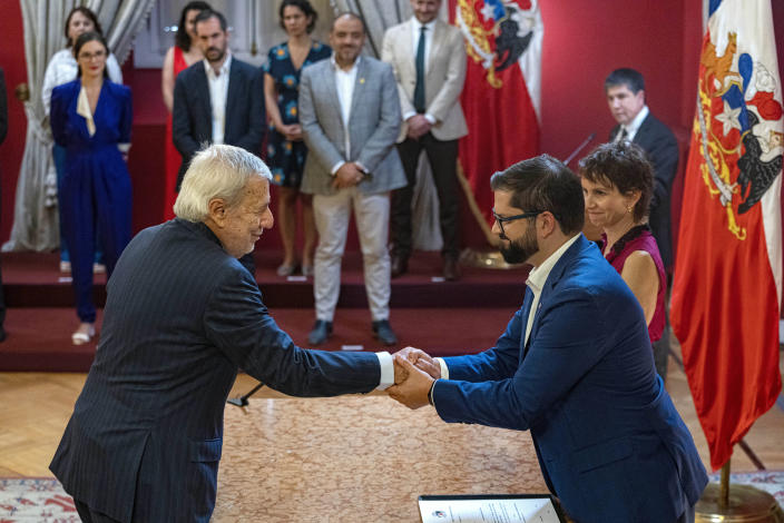 Chilean President Gabriel Boric, right, shakes hands with his newly-named Foreign Affairs Minister Albert van Klaveren, as Interior Minister Carolina Toha looks on, right, at La Moneda presidential palace in Santiago, Chile, Friday, March 10, 2023. Boric changed his cabinet one day before completing his first year in government. (AP Photo/Esteban Felix)