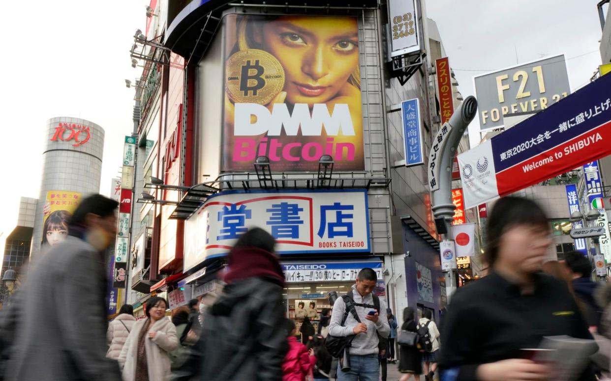 A huge advertisement of Bitcoin is displayed near Shibuya train station in Tokyo - AP