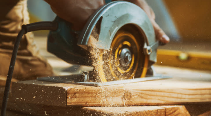 A circular saw cutting through a wooden plank