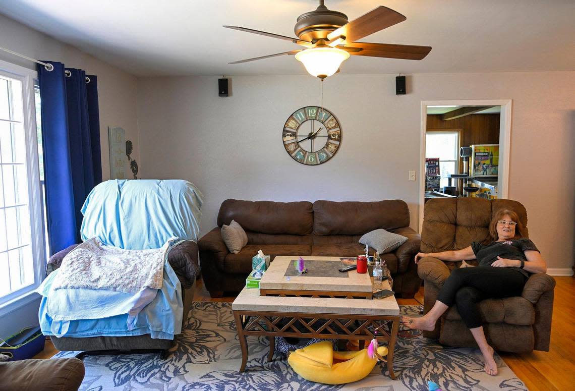 Carol Dowell takes a few minutes to rest after feeding and bathing Ellen DeFoe, 83, for whom she is a 24/7 caregiver at her home in Kansas City. DeFoe is her former mother-in-law who has late-stage Alzheimer’s disease.