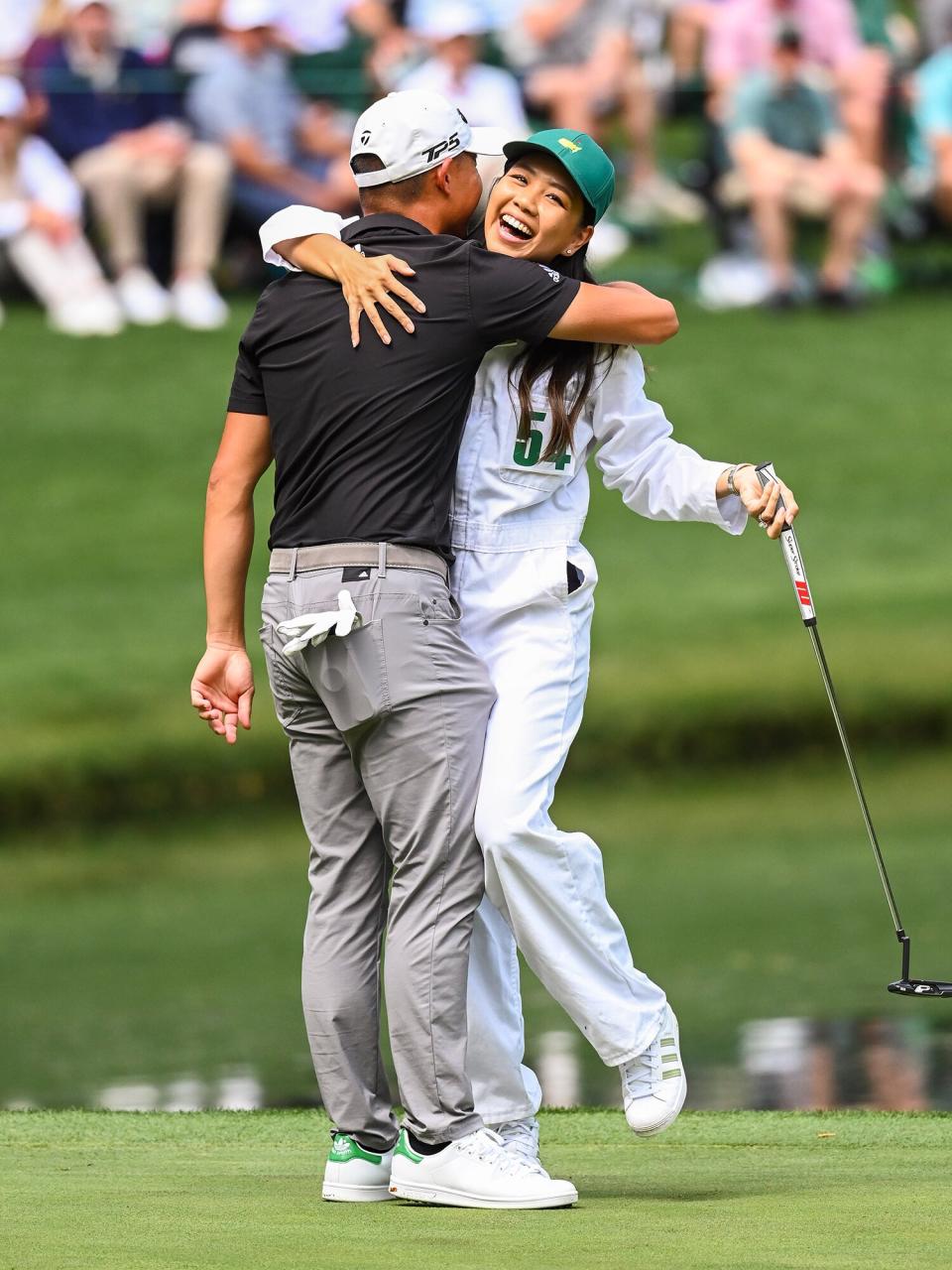 Collin Morikawa and his fiancee Katherine Zhu smile and celebrate after she made a long putt during the Par Three Contest prior to the Masters at Augusta National Golf Club on April 6, 2022, in Augusta, Georgia