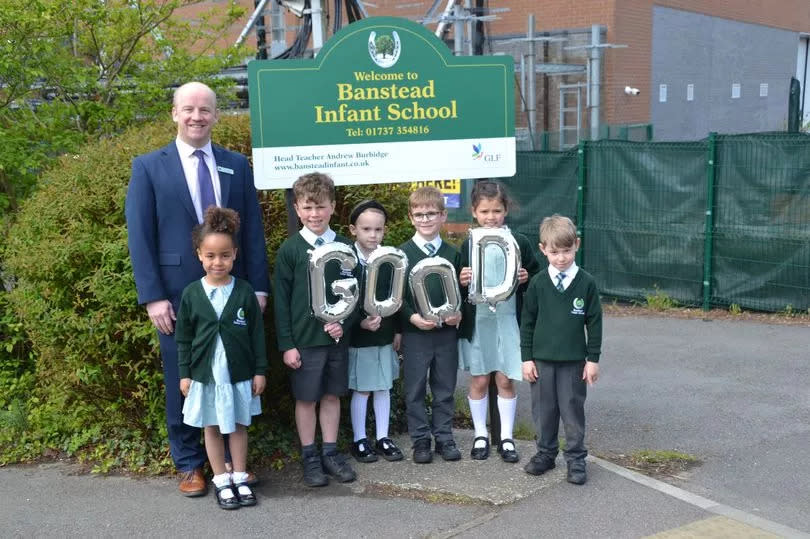 School children holding balloons outside their school to celebrate 'Good Ofsted rating. (Image: Banstead Infant School)