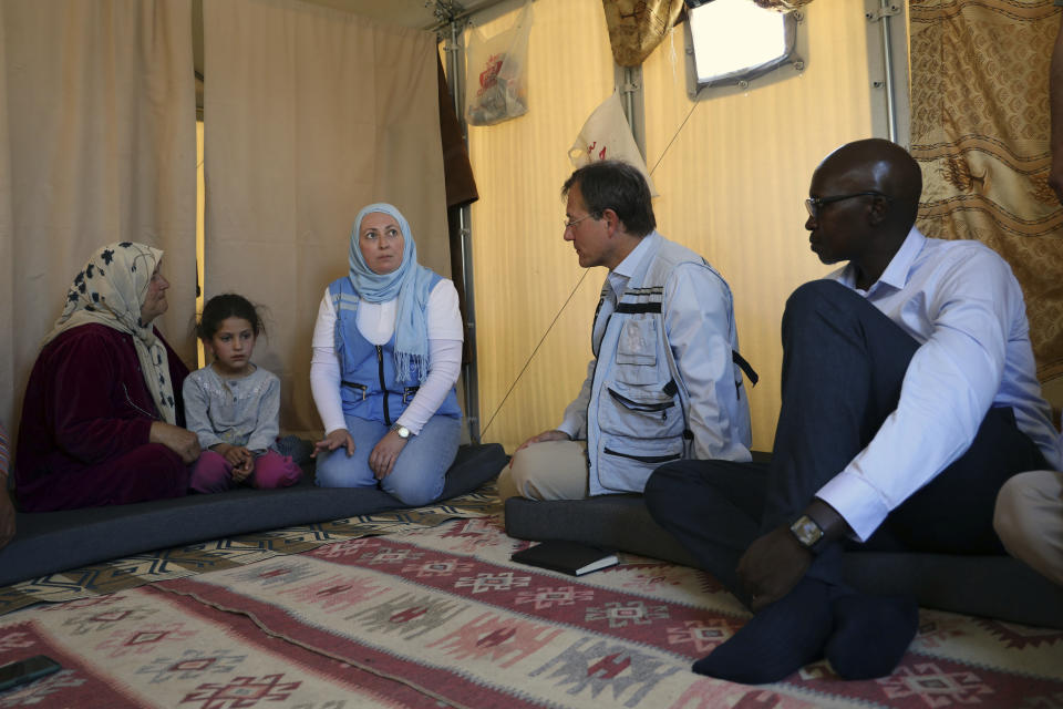 Patrick Mutai, right, a coordinator on shelters at the U.N. refugees agency, andvDavid Carden, the U.N.’s Deputy Regional Humanitarian Coordinator for the Syria crisis speak with residents at a camp in Idlib province, Syria, Wednesday, May 3, 2023. Three U.N. officials who visited Syria's Idlib province on Wednesday said some progress has been made but still more needs to be done to help the population in the rebel-held northwest that is home to some 4 million people. (AP Photo/Omar Albam)