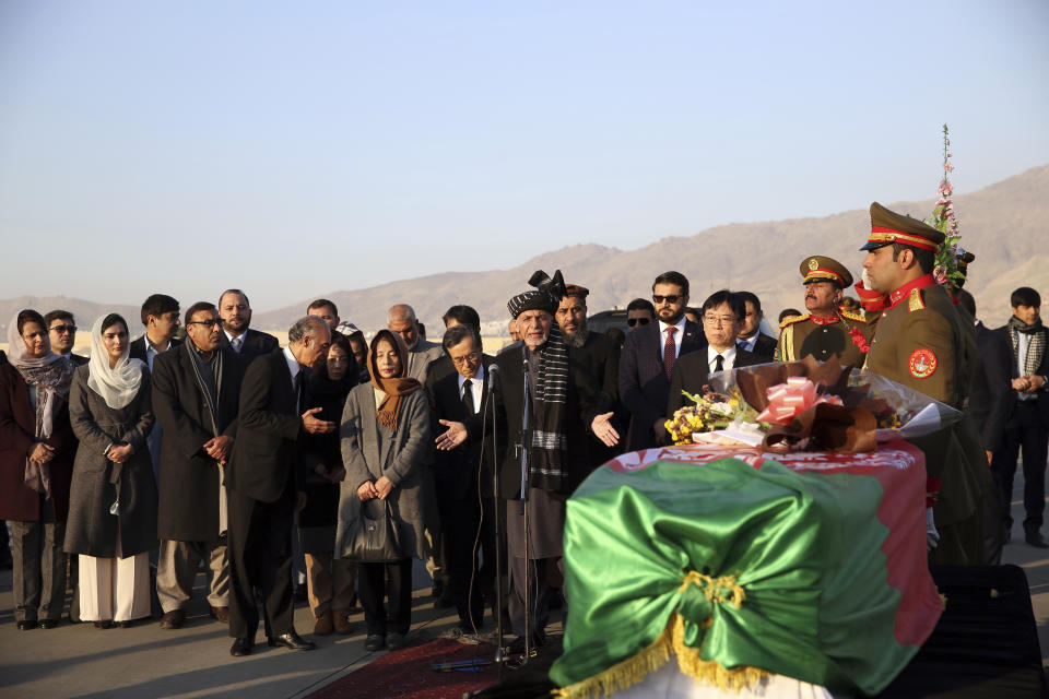 Afghan President Ashraf Ghani, speaks, next to the coffin of Japanese physician Tetsu Nakamura during a ceremony before transporting his body to his homeland, at the Hamid Karzai International Airport in Kabul, Afghanistan, Saturday, Dec. 7, 2019. Nakamura was killed earlier this week in a roadside shooting in eastern Afghanistan. (AP Photo/Rahmat Gul)