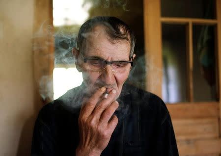 Temur Batirashvili, father of Tarkhan Batirashvili, smokes during an interview at his home in the village of Birkiani in the Pankisi Gorge, Georgia, May 19, 2016. REUTERS/David Mdzinarishvili/Files