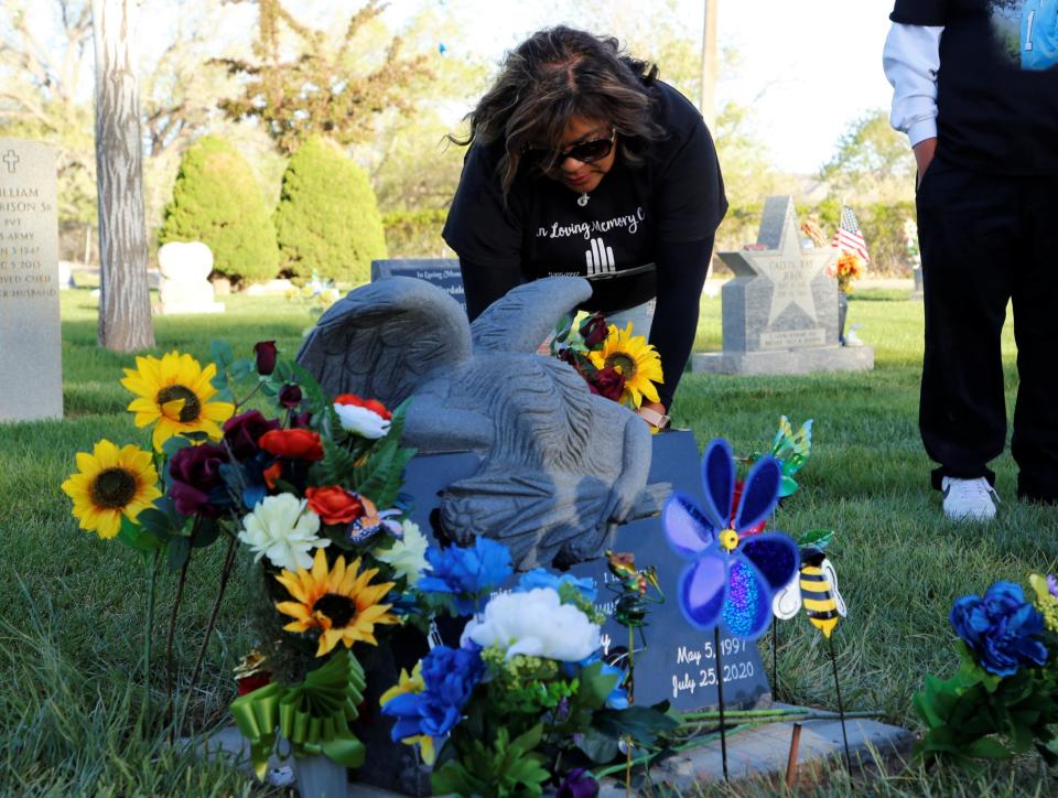 Zachariah Juwaun Shorty's mother, Vangie Randall-Shorty, places flowers on his grave on May 5 at the Kirtland-Fruitland Cemetery in Kirtland. The remembrance event recognized what would have been Shorty's 25th birthday and to raise awareness about missing and murdered Indigenous people.