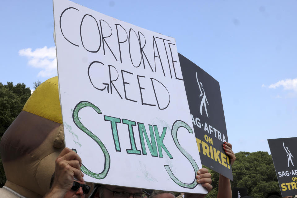 Striking screenwriters and actors hold signs at a rally in Chicago Thursday, July 20, 2023, as the labor dispute that has halted Hollywood spreads to more cities. (AP Photo/Teresa Crawford)