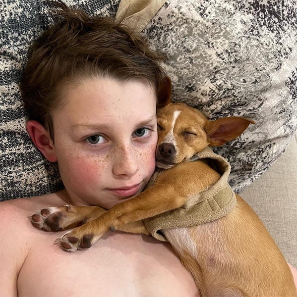 John Travolta son cuddling a dog