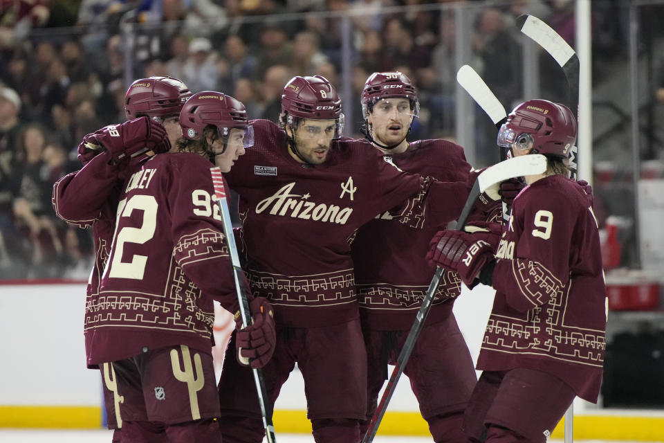 Arizona Coyotes center Nick Schmaltz celebrates with teammates after scoring against the St. Louis Blues in the second period during an NHL hockey game, Wednesday, Nov. 22, 2023, in Tempe, Ariz. (AP Photo/Rick Scuteri)